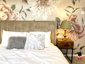a bedroom with a bed with flowers on the wall at KozyGuru / 2 BR 4Bed / Blossom Garden / Next to Big Retail Park and Train station / Worsley Manchester / 16 mins to City Centre / UMWO187 in Worsley