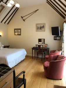 a bedroom with a bed and two chairs and a desk at Church Hill Farm in Lighthorne
