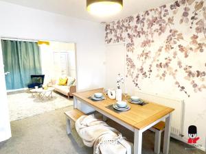 ein Wohnzimmer mit einem Tisch und einem Sofa in der Unterkunft KozyGuru / 2 BR 4Bed / Blossom Garden / Next to Big Retail Park and Train station / Worsley Manchester / 16 mins to City Centre / UMWO187 in Worsley