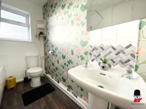 une salle de bain avec un lavabo et des toilettes dans l'établissement KozyGuru / 2 BR 4Bed / Blossom Garden / Next to Big Retail Park and Train station / Worsley Manchester / 16 mins to City Centre / UMWO187, à Worsley