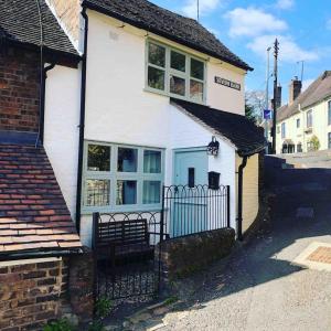 a white house with a blue door on a street at Charming 1-Bed Cottage located in Ironbridge in Ironbridge