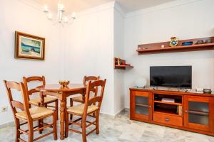 uma sala de jantar com uma mesa e uma televisão em Miraflores sea view apartment Ref 127 em Sitio de Calahonda