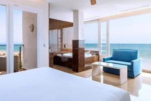a bedroom with a bed and a blue chair at Playasol in Roquetas de Mar