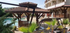a cat sitting on a wooden pergola next to a pool at Utopia Apartments Primorsko in Primorsko