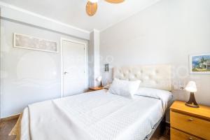 a white bedroom with a bed and a dresser at Apartamento Buen Consejo in Torremolinos
