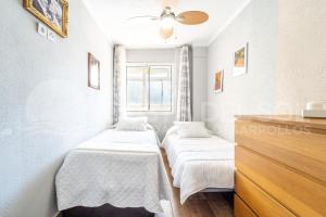 two beds in a small room with a window at Apartamento Buen Consejo in Torremolinos