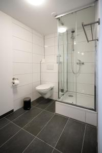 a bathroom with a toilet and a glass shower at Oldtown Studio Apartment with 2 Bathrooms in Düsseldorf