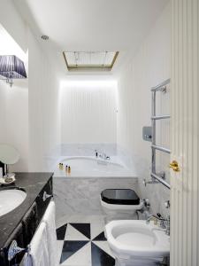 a bathroom with a tub and a toilet and a sink at Hotel Regency - Small Luxury Hotels of the World in Florence