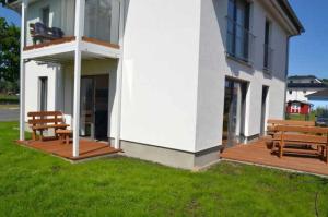 two benches sitting on a deck next to a building at Peenemünde, Fewo zum Segler in Peenemünde