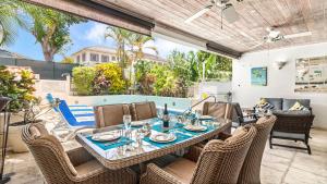 a patio with a table and chairs and a pool at Nanpa, Luxury Family Three Bed Villa, St James West coast, Private pool in Saint James