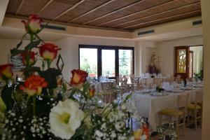una habitación con mesas y sillas con rosas y flores en Alle Querce Hotel Ristorante, en Castelbuono