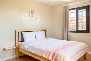 - une chambre avec un lit avec une couverture rayée et une fenêtre dans l'établissement Fully Furnished and Stylish Villa in Izmir, à Izmir