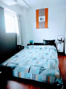 1 dormitorio con 1 cama con un edredón colorido en aup178, en Sapporo