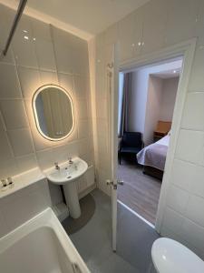 ein Badezimmer mit einem Waschbecken, einem WC und einer Badewanne in der Unterkunft The Westlynne Apartments in Manchester