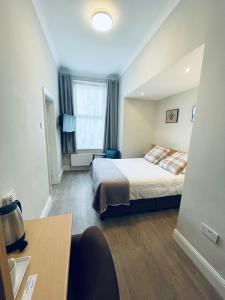 a small bedroom with a bed and a window at The Westlynne Apartments in Manchester