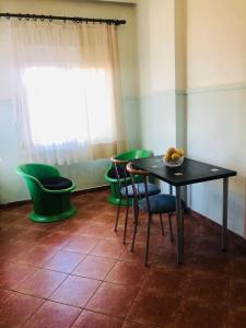 a dining room with a table and some green chairs at Two bedroom apartment in Historical area in Thessaloniki