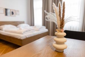 a room with a table with a vase with a plant in it at Nadland Apartments B61 in Vienna