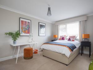 1 dormitorio con cama, escritorio y ventana en Pass the Keys Stylish 2 Bedroom Flat Apartment with Free Parking in Windsor, en Windsor