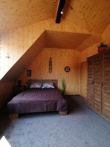 a bedroom with a bed in a wooden room at Cozy attic studio in Braşov