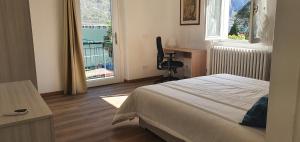 a bedroom with a bed and a desk and a window at L For Lake in Mandello del Lario