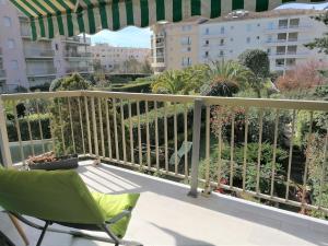 a balcony with a chair and an umbrella and some buildings at Palais Royal, plages à pied, centre St Raphael in Saint-Raphaël