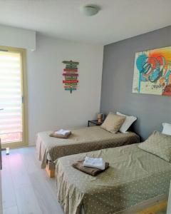 a bedroom with two beds and a painting on the wall at Palais Royal, plages à pied, centre St Raphael in Saint-Raphaël