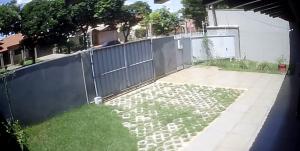 einen Hinterhof mit einem Zaun und einem Garten in der Unterkunft DOURADOS GUEST FLAT HOUSE in Dourados