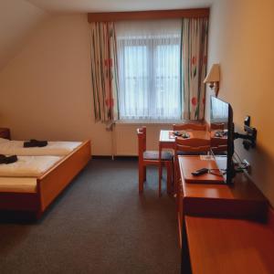 a hotel room with two beds and a desk and a table at Gasthof Kögerlwirt in Göstling an der Ybbs