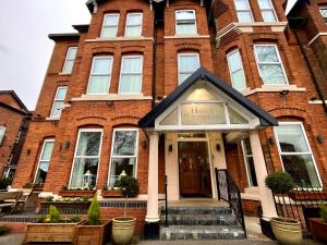 a brick building with a hotel sign in front of it at The Westlynne Apartments in Manchester