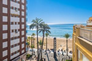 widok na plażę z palmami i oceanem w obiekcie Penthouse Ancla 562 Levante Beach w mieście Benidorm