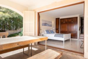 ein Schlafzimmer mit einem Bett und einem großen Fenster in der Unterkunft Villa Xapala - Cala Ratjada in Cala Ratjada