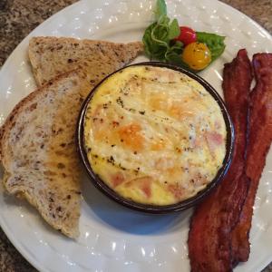 un plato de comida con huevos, tostadas y tocino en Colborne Bed and Breakfast, en Goderich