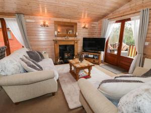 a living room with two couches and a television at 6 Astbury Falls in Bridgnorth