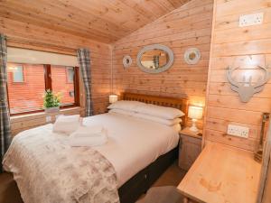 a bedroom with a bed in a wooden cabin at 6 Astbury Falls in Bridgnorth