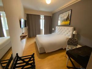 una camera d'albergo con letto, tavolo e scrivania di Hotel Palace del Conero a Osimo