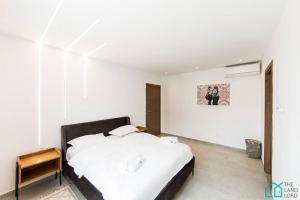 Un dormitorio blanco con una gran cama blanca. en Sunset 204 Luxury 2bds with Gym en Túnez