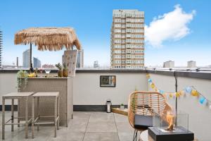 a patio with a grill and chairs on a roof at Livestay-Luxury London Penthouse with Enviable Views in London