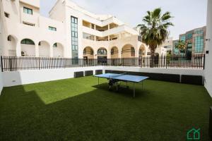 a ping pong table on a lawn in front of a building at Sunset 204 Luxury 2bds with Gym in Tunis