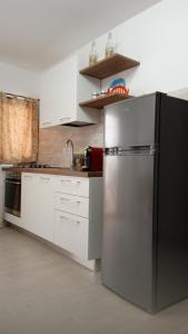 una cucina con frigorifero in acciaio inossidabile e armadietti bianchi di Savoca Loft S. Antonio a Savoca