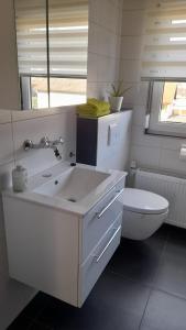 a white bathroom with a sink and a toilet at Fremdenzimmer am Brunnen in Großheubach