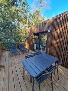 une table bleue et des chaises sur une terrasse en bois dans l'établissement Le Cube, à Sommières