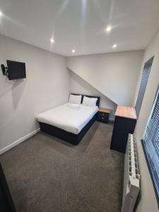 巴恩斯利APARTMENT in BARNSLEY CENTRAL的一间有一张床和一台电视的小房间