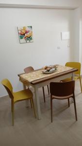 un tavolo con quattro sedie e un dipinto sul muro di Savoca Loft S. Antonio a Savoca