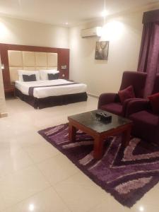 a bedroom with a bed and a couch and a coffee table at Nawara Hotel in Riyadh