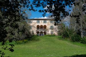 an exterior view of a large stone house with a yard at NEW! La Stanza in Villa in Lucca
