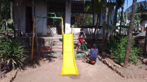 two children playing on a yellow slide in a playground at Tendulkar Beach Resort in Diveagar