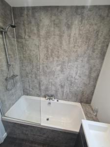a bathroom with a bath tub with a shower at APARTMENT in BARNSLEY CENTRAL in Barnsley