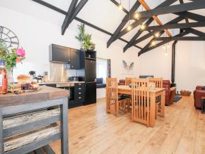 Owl Barn في ليسكيرد: مطبخ وغرفة معيشة مع طاولة وكراسي