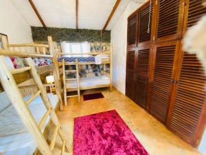 a room with bunk beds and a red rug at Home OnThe Nile Dorm in Jinja