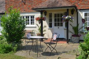 a table and chairs in front of a house at The Willow Studio - peaceful retreat near Whitstable seaside in Kent